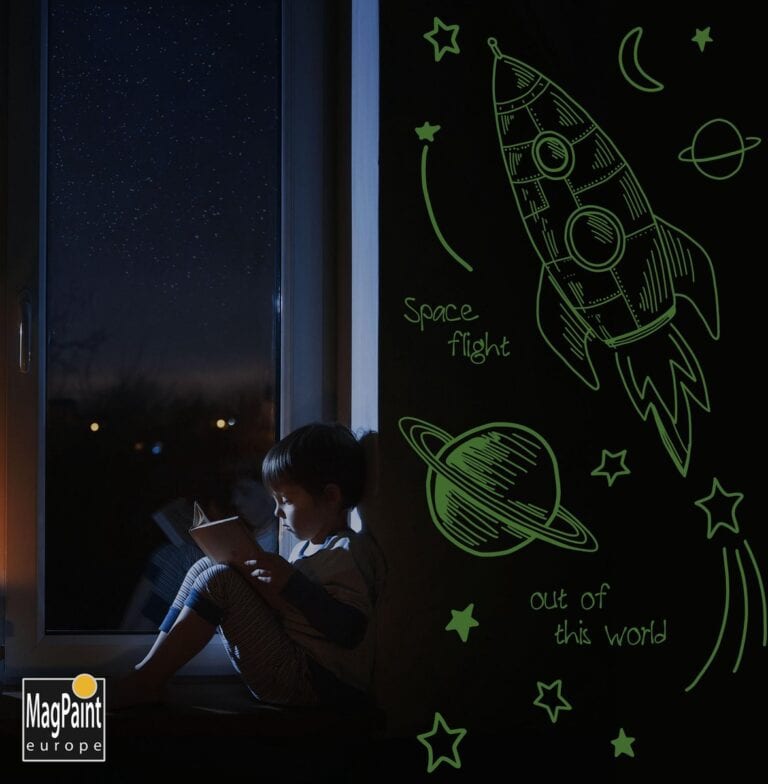 Kind liest nachts neben leuchtenden Weltraumzeichnungen aus GlowPaint