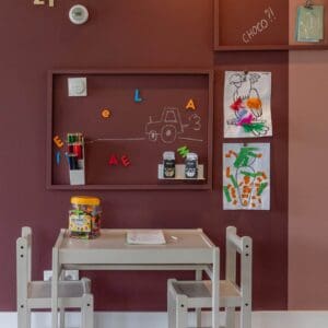 Kinderzimmer mit Tischchen und Stühlen an rosa Wand Kinderzimmer mit weißem Kindertischchen und Stühlen an einer rosa Wand