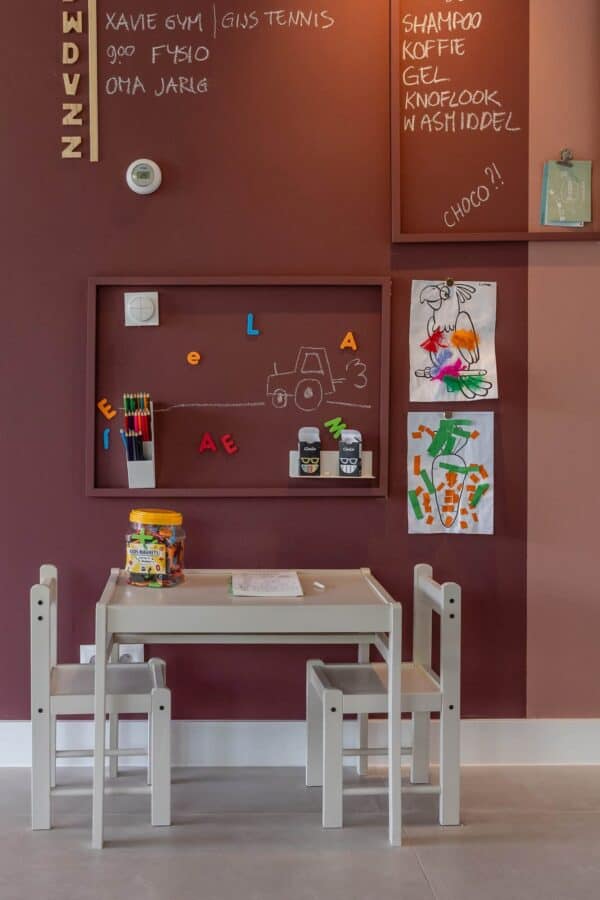 Kinderzimmer mit Tischchen und Stühlen an rosa Wand Kinderzimmer mit weißem Kindertischchen und Stühlen an einer rosa Wand