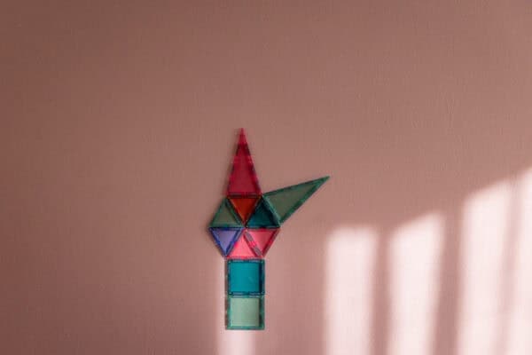 Magnetische Bausteine an der rosa Wand Magnetische Bausteine an einer mit MagnetFarbe gestrichenen rosa Wand