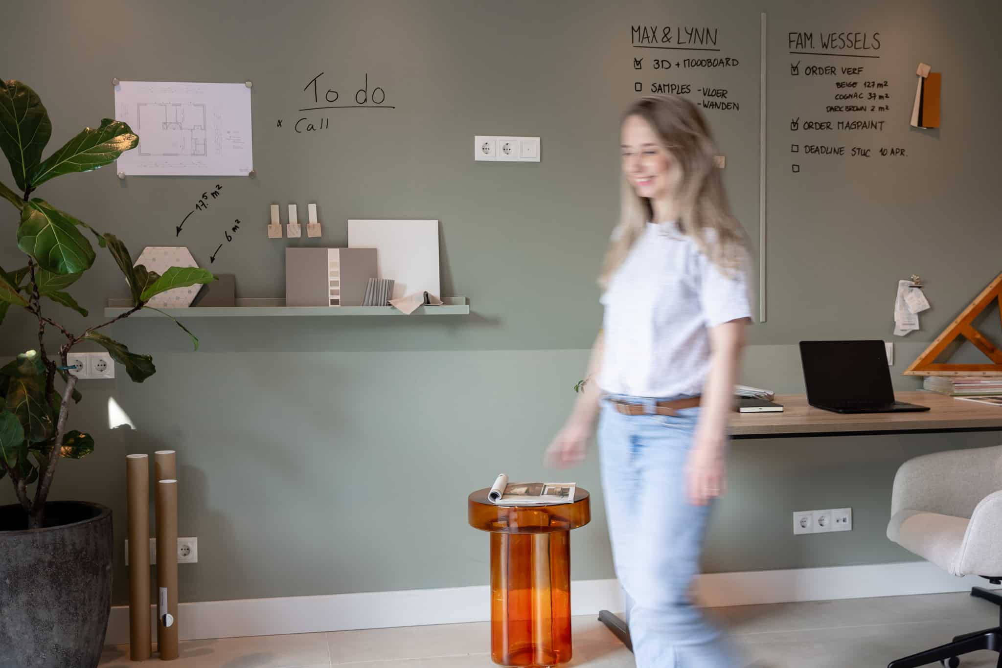 Frau schreibt mit einem Marker an einer mit SketchPaint gestrichenen Whiteboardwand